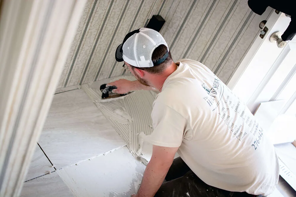 Honey Do Master Craftsman troweling mortar to lay tile