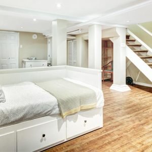 A finished basement room with wooden entrance stairs