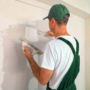 A The Honey Do Service craftsman patching up several damaged sections of drywall