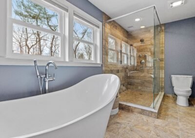 Modern bathroom remodel with white subway tiles, frameless glass shower, and double vanity