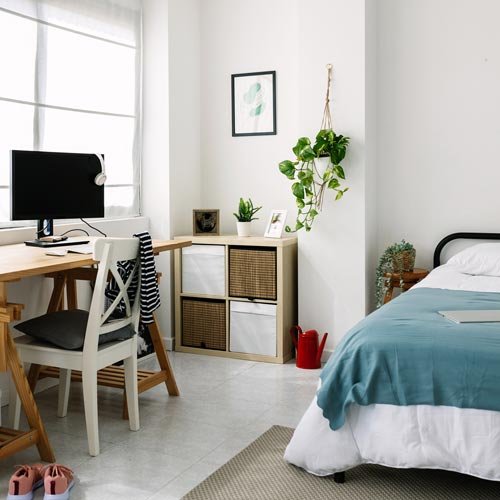 Cozy interior millennial teenage room with bed, laptop and desk